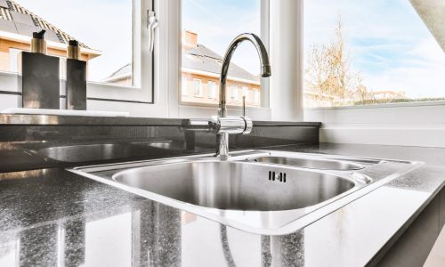 Silver kitchen sink on the black cupboard